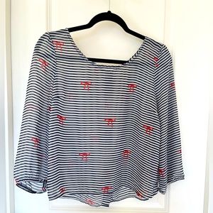 Sheer striped shirt with red button accent